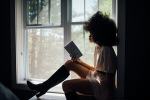 Woman reading best personal finance books by window